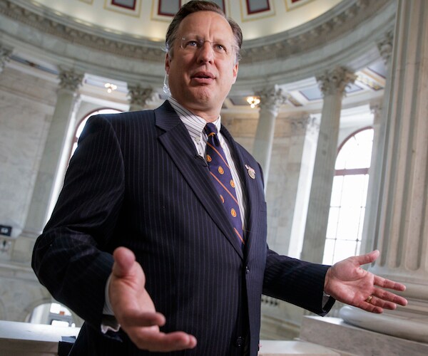 former virginia republican representative david brat extends both hands palms up while speaking to reporters