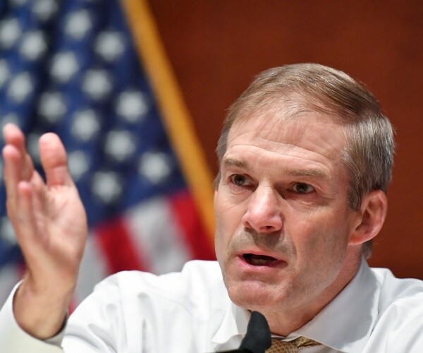 jim jordan in a white dress shirt and us flag in the background