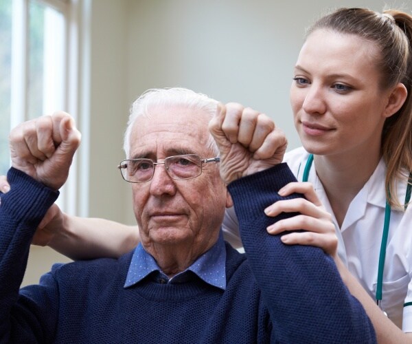 nurse helping stroke patient raise arms