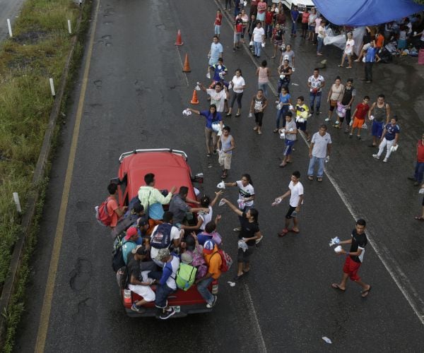 mexicans from religious organizations hand out small bags to central american migrants in mexico. 