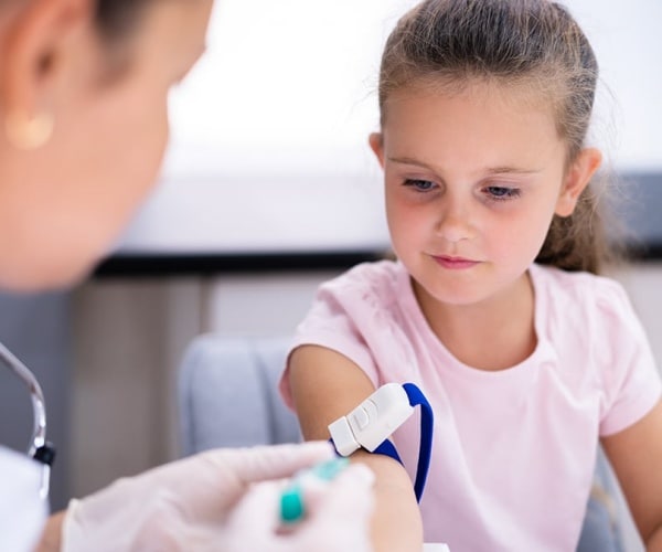 doctor taking blood from a young girl