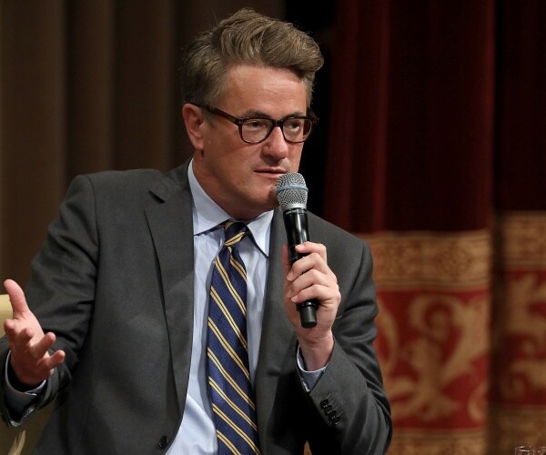 scarborough in a dark gray suit and blue striped tie