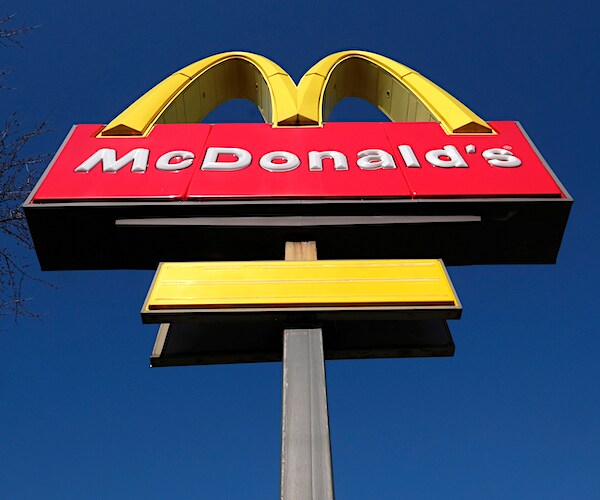 the mcdonald's golden arches stand tall against a clear, bright blue sky