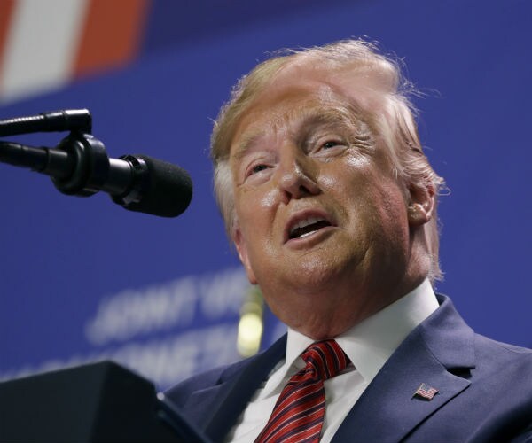 president donald trump is shown in a blue suit with an american flag on his lapel