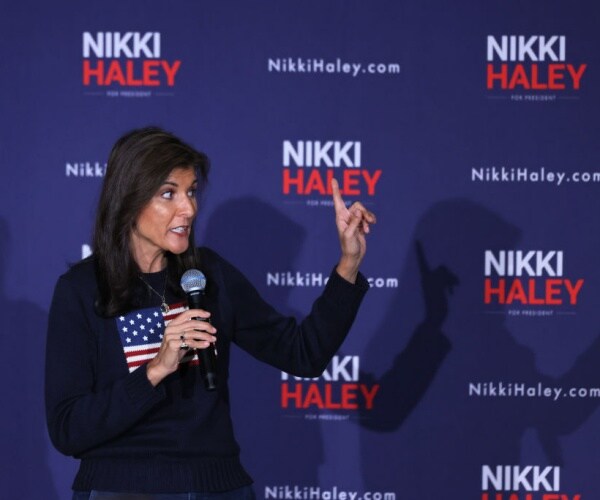 nikki haley wear american flag sweater and holds mic while pointing