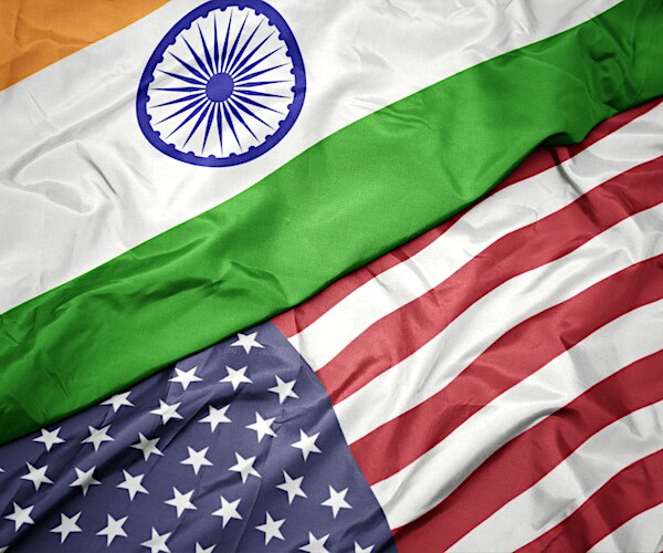 waving colorful flag of united states of america and national flag of india