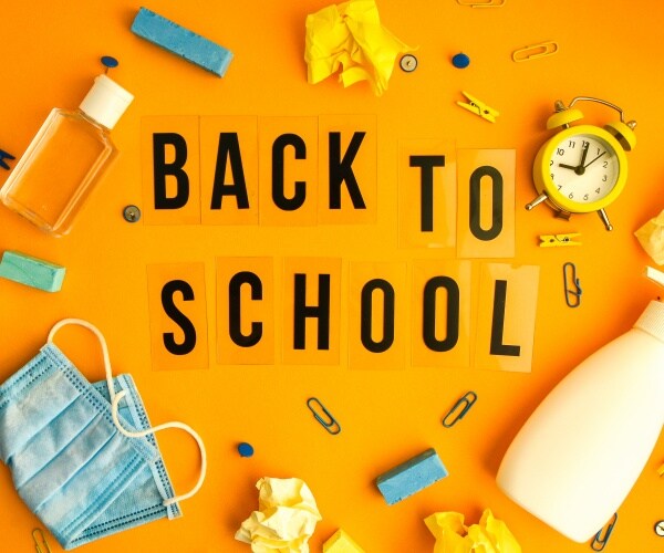 "Back to School" surrounded by pencils, surgical mask, hand sanitizer and other school supplies