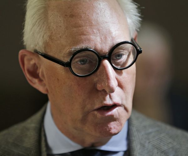 roger stone talks to people outside a courtroom in new york.