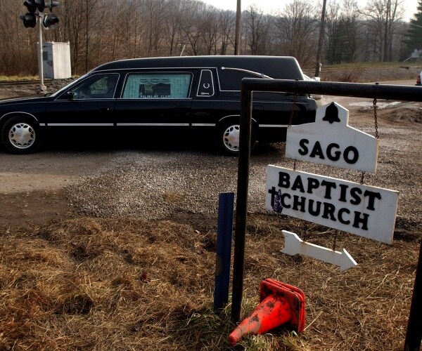 black car parked outside a sign for sago baptist church