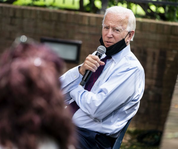 presidential candidate former vice president Joe Biden is shown speaking with a black mask lowered