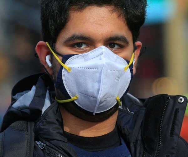 man wears two face masks stacked on top of each other