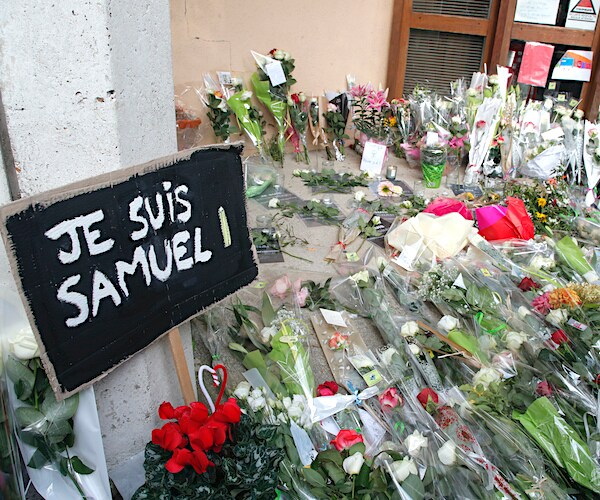 A poster reading "I am Samuel" and flowers lay outside the school in Conflans-Sainte-Honorine, northwest of Paris