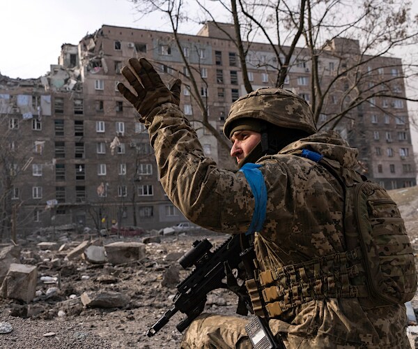 A Ukrainian soldier surveys the damage in mariupol, ukraine