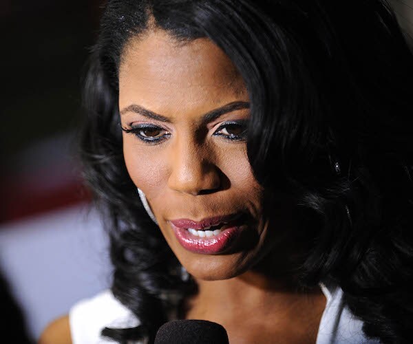 Omarosa Manigault Newman looks down as she speaks to the media