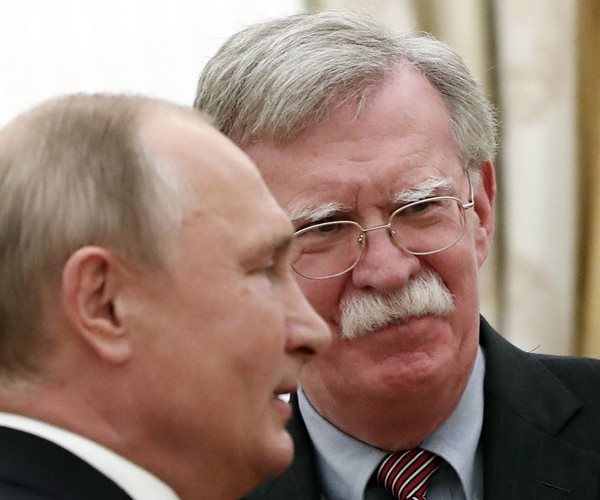 vladimir putin seen in profile standing close to john bolton who faces the camera