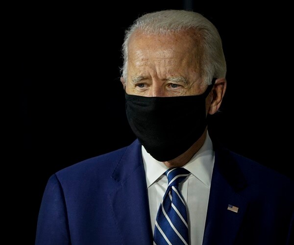 joe biden wears a mask as he arrives at an event