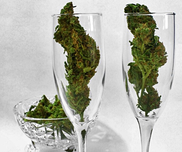 Two wine glasses with cannabis buds to symbolize marijuana laced drinks