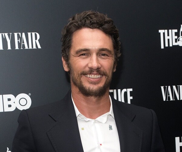 james franco stands on red carpet