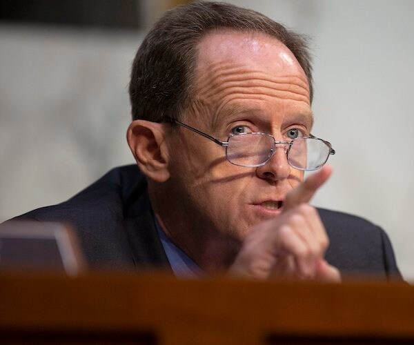 pat toomey looks over the rim of his glasses as he points and speaks during a senate hearing