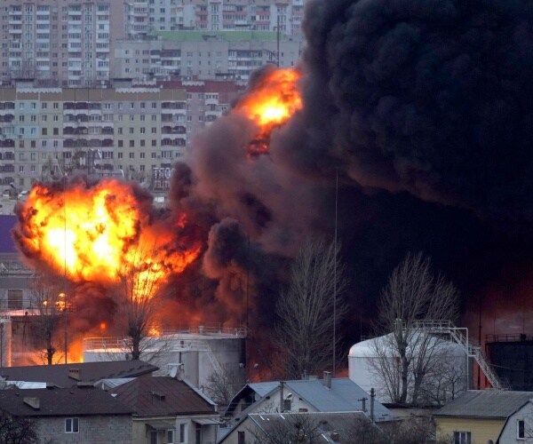 blazing fire and black smoke rise from an oil storage facility