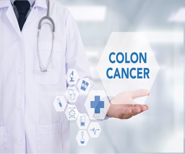 Doctor holding an image with "colon cancer" on it and other images floating around - stethoscope, etc. 