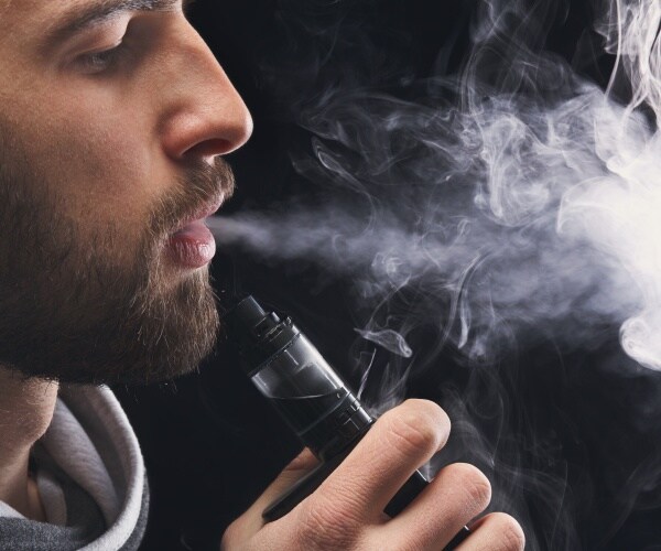 man with beard smoking an e-cigarette