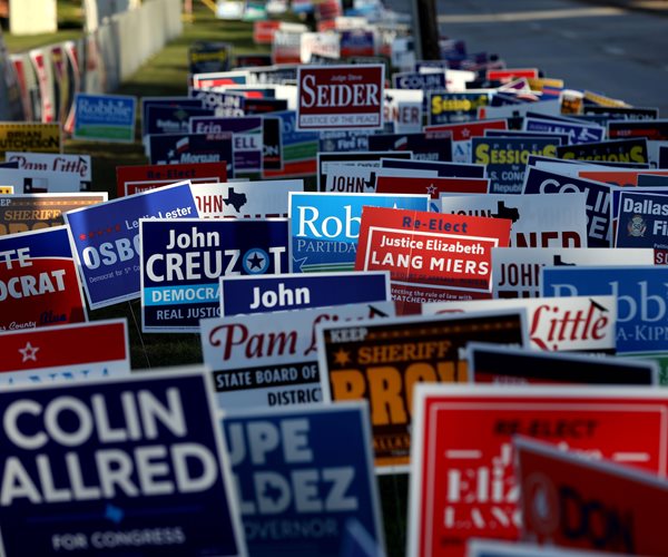 campaign signs crowded together outside a polling station in dallas 