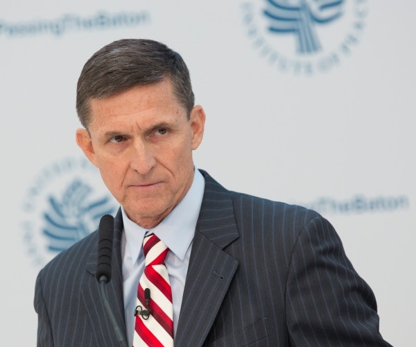 flynn in a striped gray suit blue shirt and red and white striped tie