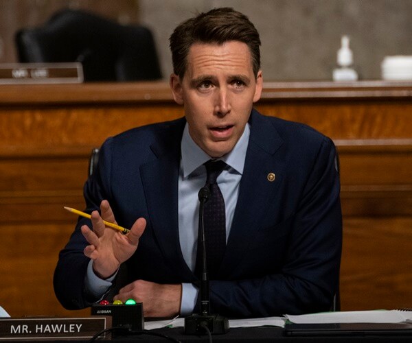 josh hawley speaks while seated with a pencil in his hand