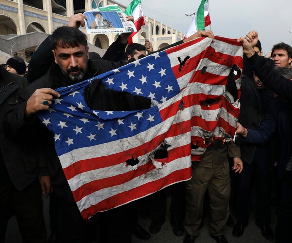 protesters in iran burn an American flag