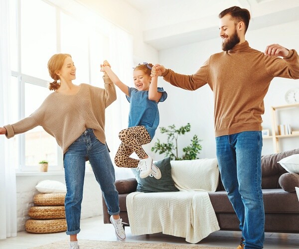 mother and father swing daughter in between them