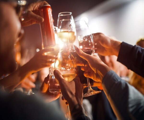 friends at a table clinking wine glasses