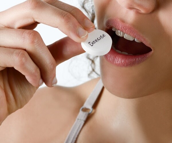 woman putting a pill in her mouth that says 'exercise' on it