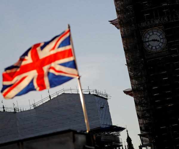 the british flag flies with big ben in the background