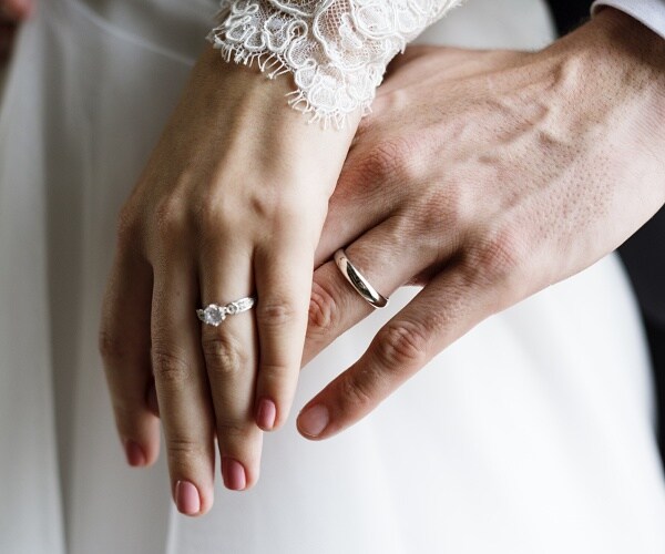 bride and groom showing their wedding rings