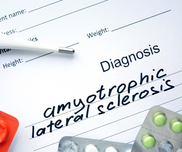 Diagnosis pad says 'amytrophic lateral sclerosis' with some pills and a stethoscope near it