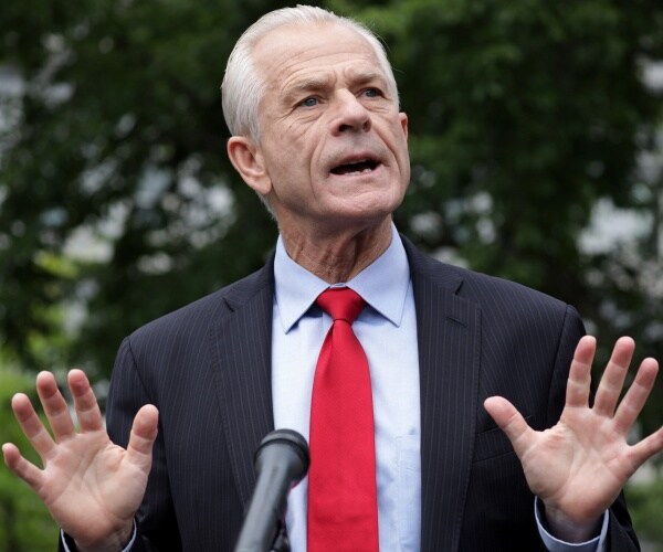 navarro in a suit and red tie standing outside