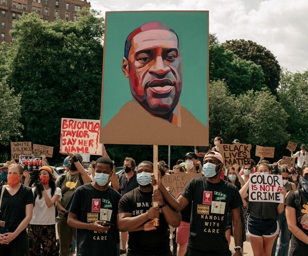 demonstrators hold up a sign with george floyd's face