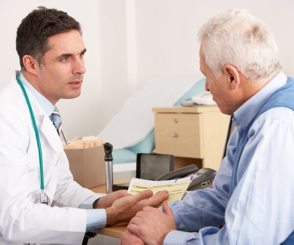 older man talking to doctor about symptoms