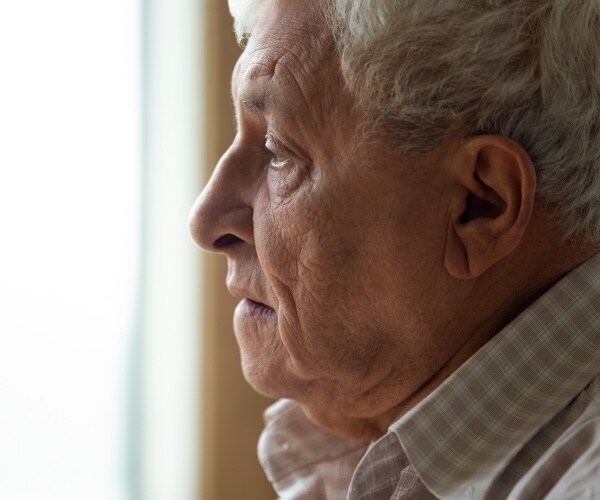 close up of older man's profile, looking sad