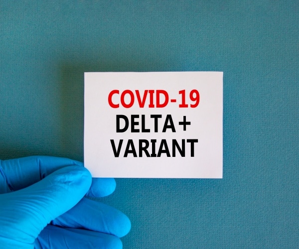 COVID-19 Delta Plus variant note held by gloved hand