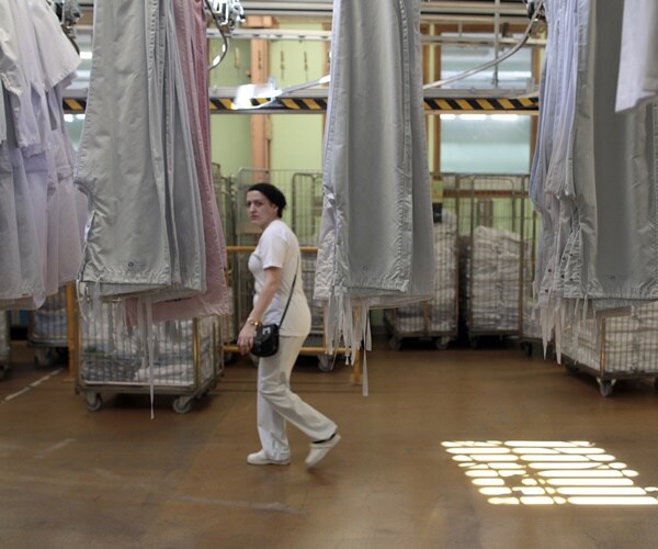 woman walks through hospital laundry