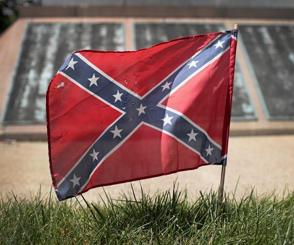 a confederate flag is planted next to a monument