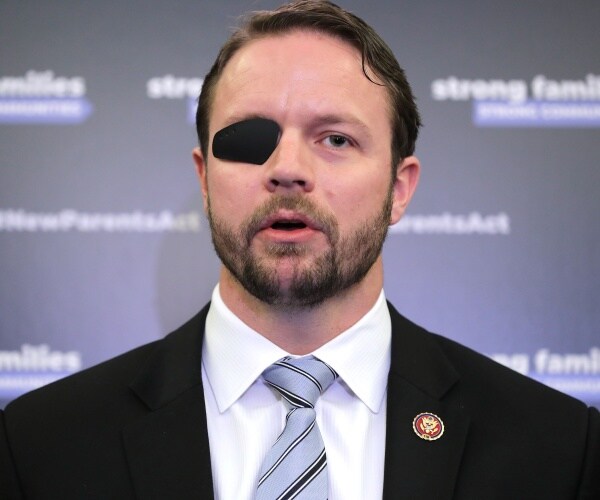 crenshaw in a black suit and light blue striped tie