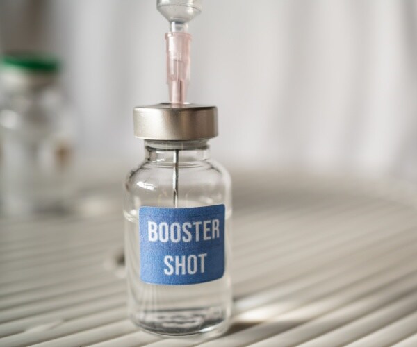 syringe in vial labeled "booster shot"