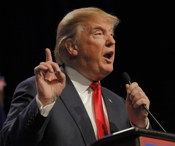 donald trump at microphone speaking and pointing with finger