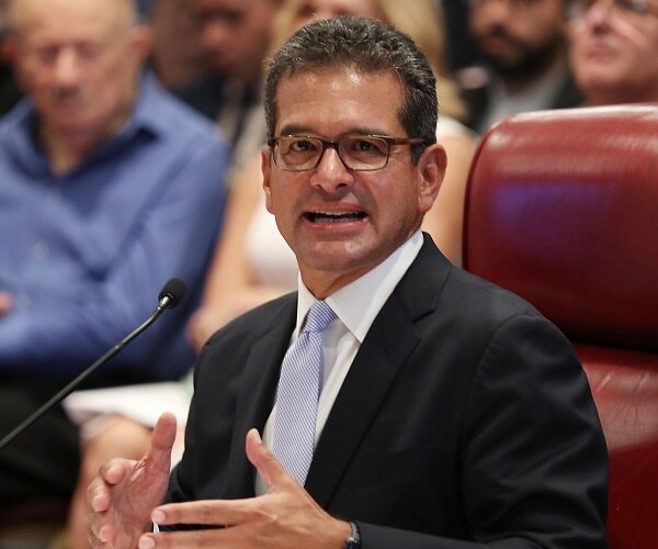 pedro pierluisi sits in chair 