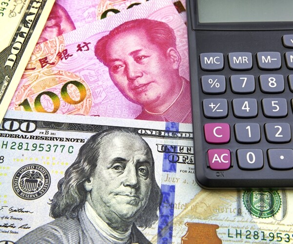 one hundred dollar and china yuan bills with calculator 

