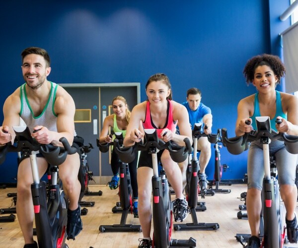 two women and a man on bikes in spin class