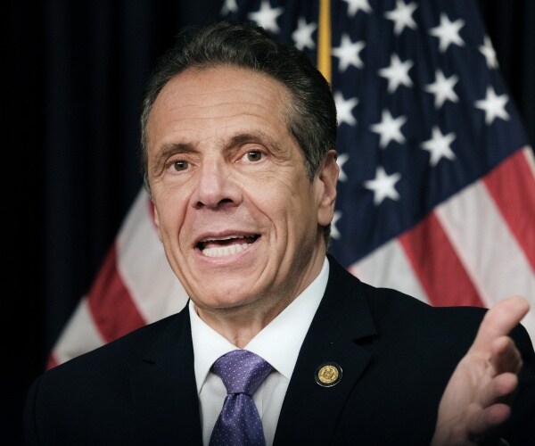 New York Governor Andrew Cuomo speaking in front of a U.S. flag